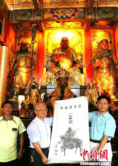 10月18日,朱正明(右)向高雄關(guān)帝廟主委黃富濃(中)贈送岳飛畫關(guān)公古碑拓片 鐘新 攝