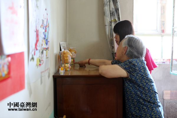 田紫云老人指著臥室擺放的照片,興奮地向高雄客人介紹家里的晚輩們。 田紫云老人指著臥室擺放的照片,興奮地向高雄客人介紹家里的晚輩們。