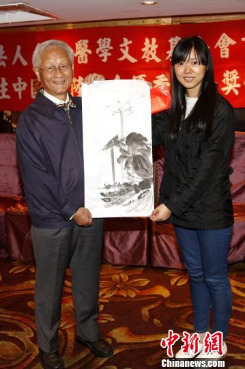 1月4日晚,“蔡振良先生中國大陸來臺優秀研修生獎助金”頒獎活動在臺北舉行。圖為獲獎在臺陸生向臺灣名儕醫學文教基金會董事長李源德教授(左)贈送畫作。 陳小愿 攝