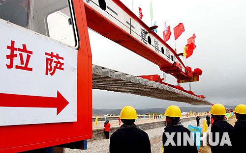 西藏境內(nèi)第一段鐵路軌排在安多火車站鋪下,鐵軌將從這里向拉薩繼續(xù)延伸(2004年6月22日攝)。 青藏鐵路從西寧至拉薩全長(zhǎng)1956公里,是世界上海拔最高、線路最長(zhǎng)、穿越凍土里程最長(zhǎng)的高原鐵路。把鐵路修進(jìn)西藏是幾代中國(guó)人的夢(mèng)想,但這一想法直到新中國(guó)成立后才逐漸變?yōu)楝F(xiàn)實(shí)。青藏鐵路一期工程西寧至格爾木段于1958年開工,1984年交付營(yíng)運(yùn)。但限于當(dāng)時(shí)國(guó)家的經(jīng)濟(jì)實(shí)力以及高原、凍土等筑路技術(shù)難題尚未解決,格爾木至拉薩段被迫停建。2001年6月,國(guó)家總投資330.9億元?jiǎng)庸ば藿ㄇ嗖罔F路二期工程。這一工程跨越昆侖山、唐古拉山,通過多年凍土層和大片“生命禁區(qū)”,是人類鐵路建設(shè)史上亙古未有的穿越。它的建成將為神秘而古老的青藏高原帶來(lái)新的生機(jī)和活力! 新華社發(fā)