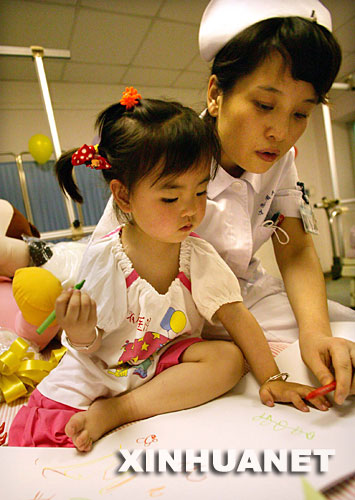 5月31日,江蘇省人民醫(yī)院的護(hù)士在愛(ài)心病房陪宋馨懿畫(huà)畫(huà)。當(dāng)日傍晚,四川地震災(zāi)區(qū)小傷員宋馨懿來(lái)到南京,進(jìn)入江蘇省人民醫(yī)院接受身體和心理的康復(fù)治療,并為安裝假肢做準(zhǔn)備。 5月14日,在地震后的四川北川縣城,被壓在垮塌房屋下的3歲小女孩宋馨懿,在遇難父母的身體翼護(hù)下與死神抗?fàn)幜?0多個(gè)小時(shí)后獲救。在醫(yī)療隊(duì)和社會(huì)各界關(guān)照下,小馨懿的身心恢復(fù)狀況良好。