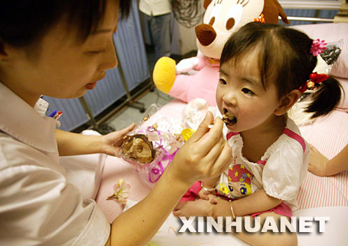 5月31日,江蘇省人民醫(yī)院的護(hù)士在愛(ài)心病房喂宋馨懿吃蛋糕。當(dāng)日傍晚,四川地震災(zāi)區(qū)小傷員宋馨懿來(lái)到南京,進(jìn)入江蘇省人民醫(yī)院接受身體和心理的康復(fù)治療,并為安裝假肢做準(zhǔn)備。 5月14日,在地震后的四川北川縣城,被壓在垮塌房屋下的3歲小女孩宋馨懿,在遇難父母的身體翼護(hù)下與死神抗?fàn)幜?0多個(gè)小時(shí)后獲救。在醫(yī)療隊(duì)和社會(huì)各界關(guān)照下,小馨懿的身心恢復(fù)狀況良好。